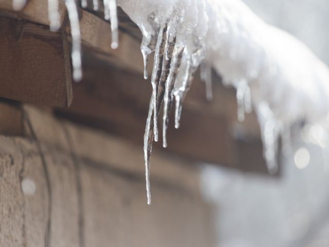 Close-up of roof with snow and icicles
